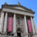 Building with pillars, and between them banners saying 'Tate Britain' and 'Free for all'