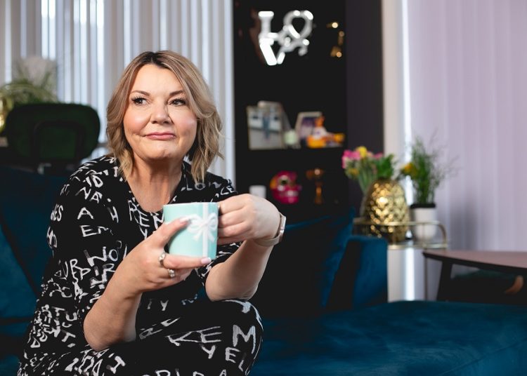 Woman in black and white dress with a mug in her hands