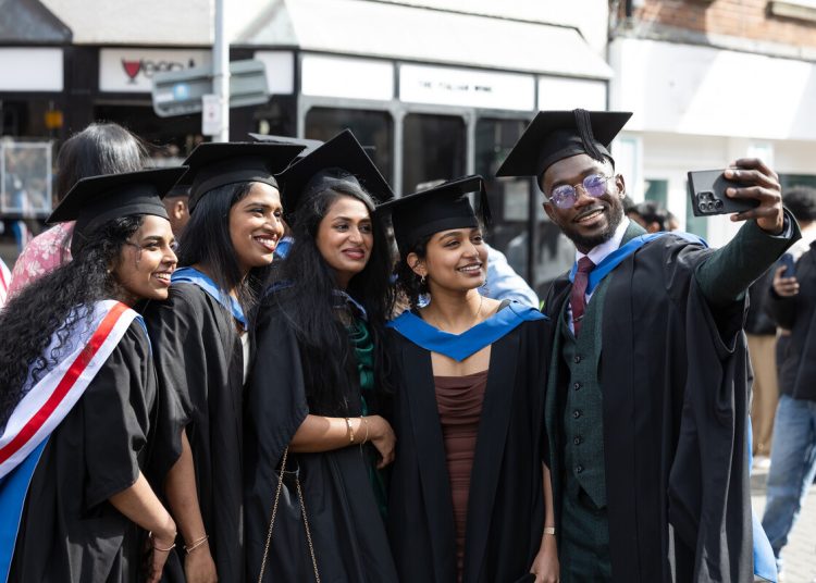 March 2026, bame, cap and gown, diversity, female, friends, graduand, graduate, graduation, group, happy, inside, international student, male, mobile phone, selfie, smile, taking photo, University of Chester