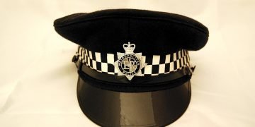 Black cap with checkered black/white band and a circle with ER and a crown above it