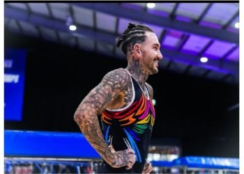 Man in gumnast outfit and with tatoos on his arm and chest